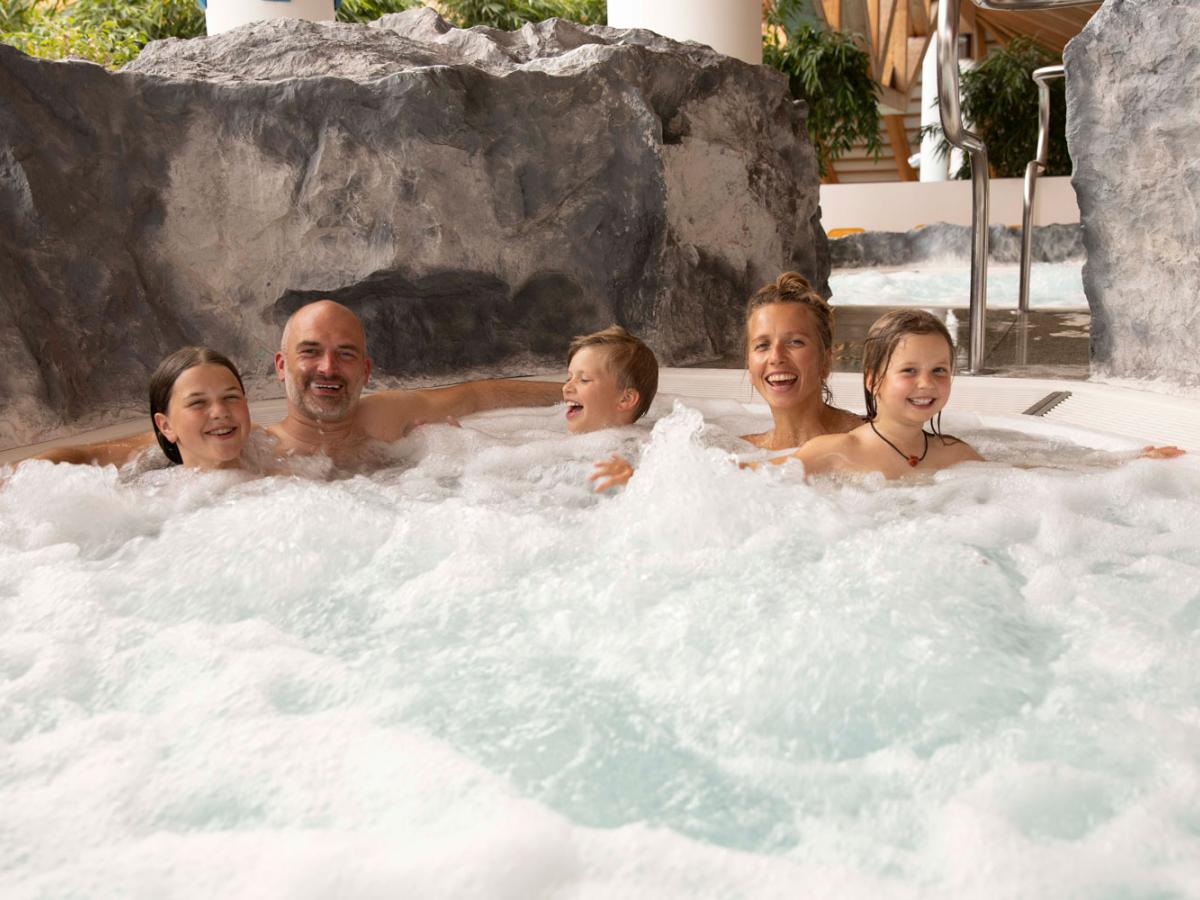 Familie badet im Whirlpool im Erlebnisbad Aquaria